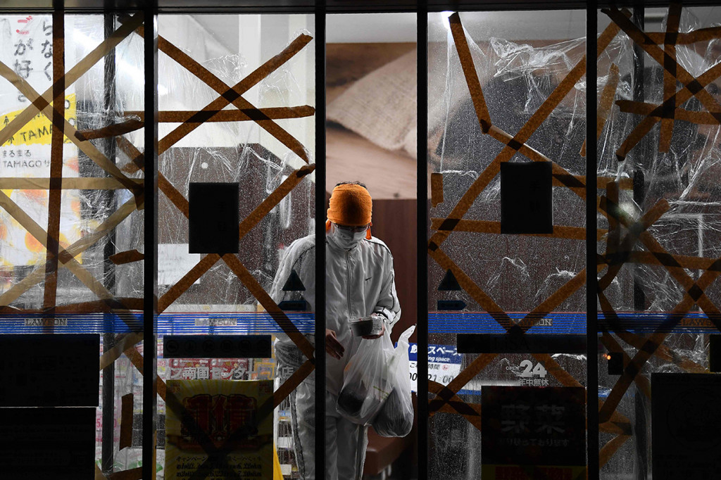 Seseorang meninggalkan toko yang dibarikade saat Topan Haishen di Kagoshima, Jepang. AFP Photo/Charly Triballeau