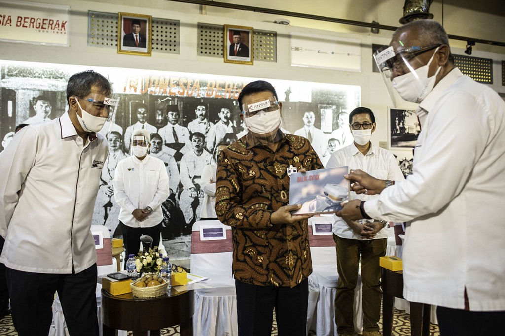 Kepala Staf Kepresidenan Moeldoko (tengah) disaksikan Direktur Utama Perum LKBN Antara Meidyatama Suryodiningrat (kiri) menerima buku foto jurnalistik Kilas Balik 2019 + COVID-19 karya pewarta foto Antara dari Direktur Pemberitaan Perum LKBN Antara Akhmad Munir (kanan) saat pembukaan dan peluncuran tur virtual Pameran Fotografi dan Grafis Indonesia Bergerak: 1900 - 1942 di Galeri Foto Jurnalistik Antara (GFJA), Jakarta.