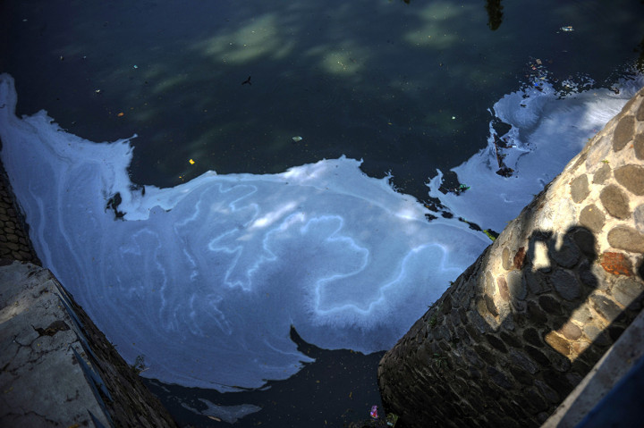 Bayangan warga yang memotret Sungai Cipamokolan yang tercemar limbah di Rancasari, Bandung, Jawa Barat, Rabu, 9 September 2020. 