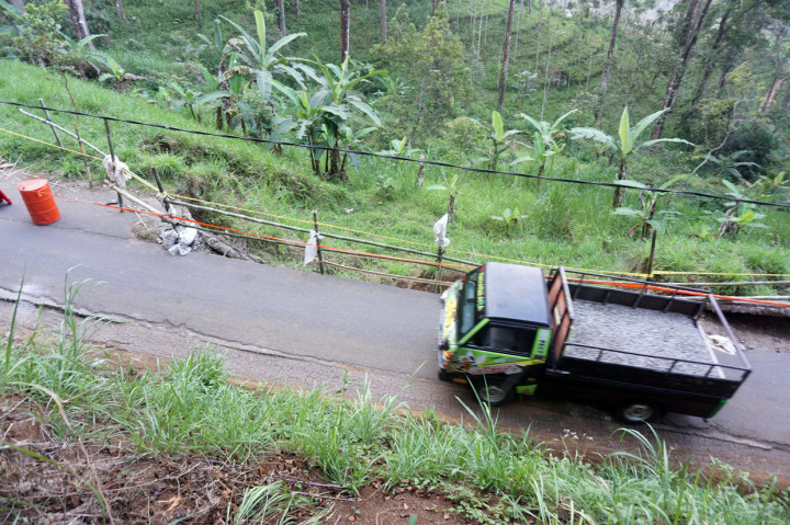 Pengendara melintas di sisi jalan sirip Tulungagung-Trenggalek yang ambrol terseret longsor di Desa Kradinan, Tulungagung, Jawa Timur, Rabu, 9 September 2020.