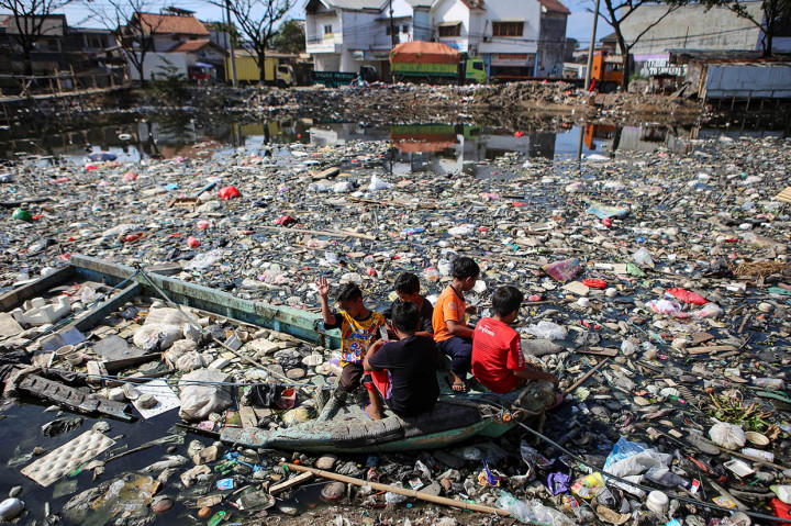 Sejumlah bocah bermain di Kali Perancis di Dadap, Kecamatan Kosambi, Kabupaten Tangerang, Banten, yang dipenuhi sampah, Rabu, 9 September 2020.