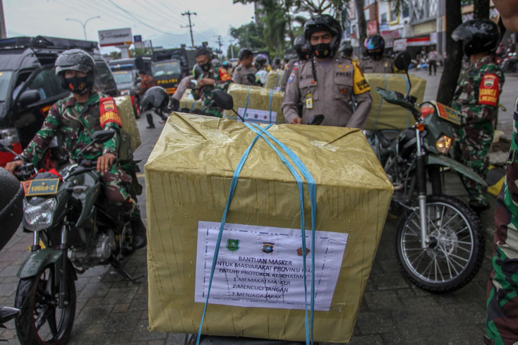 Rombongan Babinsa dan Bhabinkamtibmas bersiap untuk membagikan masker gratis kepada masyarakat di Pekanbaru, Riau.