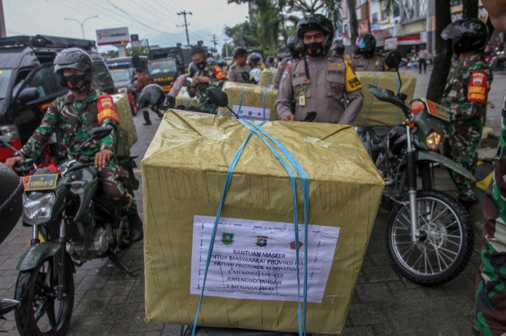 Rombongan Babinsa dan Bhabinkamtibmas bersiap untuk membagikan masker gratis kepada masyarakat di Pekanbaru, Riau.