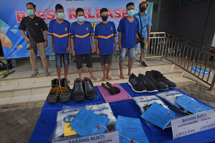 Petugas Badan Narkotika Nasional (BNN) Banten menunjukkan para tersangka penyelundup narkotika jenis sabu bersama barang buktinya saat rilis di Serang.