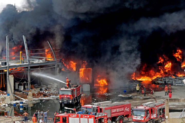 Sejumlah petugas pemadam kebakaran tengah berupaya memadam api yang membakar kawasan pelabuhan di Beirut, Lebanon.