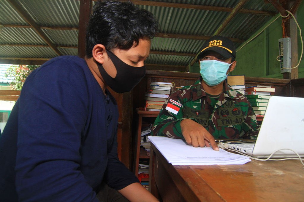 Anggota Satgas Pamtas RI-Malaysia Yonif 133/Yudha Sakti, Letda (Ckm) Wahyuddin Tarman (kanan) menguji seorang anak saat ujian Bahasa Inggris di Pos Kotis Nanga Badau, Kabupaten Kapuas Hulu, Kalimantan Barat.