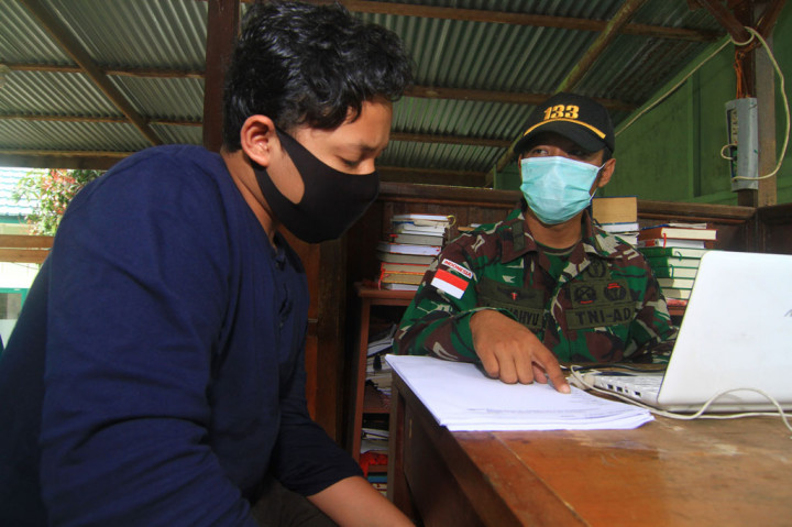 Anggota Satgas Pamtas RI-Malaysia Yonif 133/Yudha Sakti, Letda (Ckm) Wahyuddin Tarman (kanan) menguji seorang anak saat ujian Bahasa Inggris di Pos Kotis Nanga Badau, Kabupaten Kapuas Hulu, Kalimantan Barat.