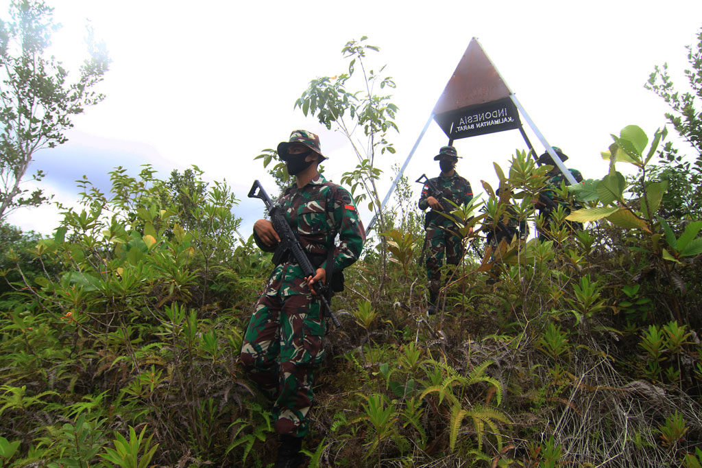 Sejumlah anggota Satgas Pamtas RI-Malaysia Yonif 133/Yudha Sakti turun dari bukit usai memeriksa patok batas saat patroli di perbatasan Badau, Kabupaten Kapuas Hulu, Kalimantan Barat.