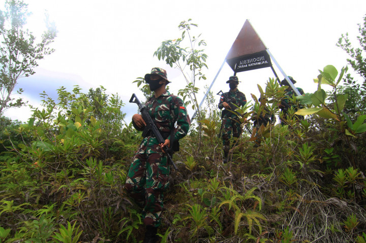 Sejumlah anggota Satgas Pamtas RI-Malaysia Yonif 133/Yudha Sakti turun dari bukit usai memeriksa patok batas saat patroli di perbatasan Badau, Kabupaten Kapuas Hulu, Kalimantan Barat.