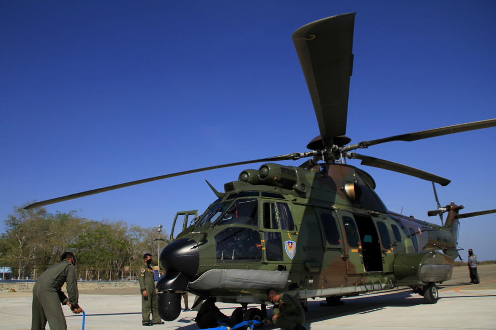 Personel TNI AU tengah memasang pengait di Heli Caracal yang baru selesai melakukan operasi perbatasan 2020 di Lanud El Tari Kupang, NTT, Selasa, 15 September 2020.