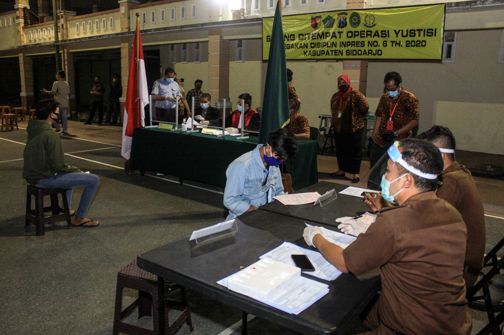 Warga yang terjaring oleh Tim Pemburu Pelanggar Protokol Kesehatan Covid-19 mengikuti sidang di tempat di Waru, Sidoarjo, Jawa Timur, Kamis, 17 September 2020.