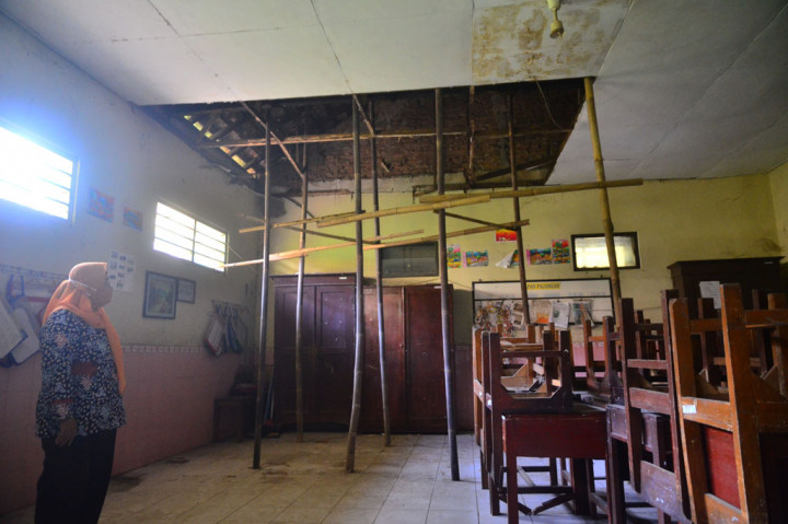 Seorang guru menunjukkan plafon yang rusak di salah satu ruangan Sekolah Dasar Negeri (SDN) 2 Purwosari, Kudus, Jawa Tengah, Jumat, 18 September 2020.