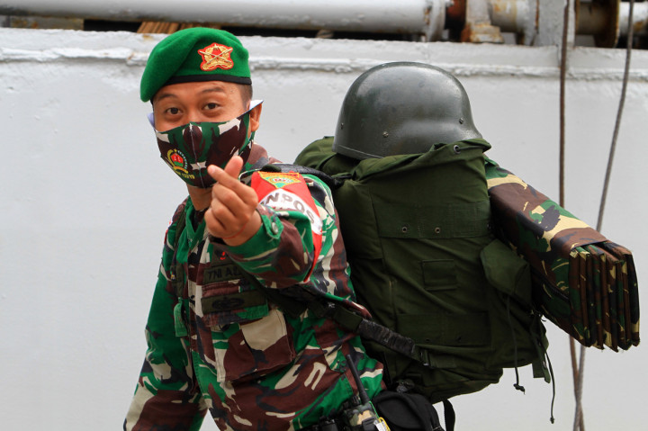 Seorang prajurit Yonif 133/Yudha Sakti mengacungkan salam cinta khas Korea Selatan saat menaiki tangga kapal di Pelabuhan Dwikora Pontianak, Kalimantan Barat.