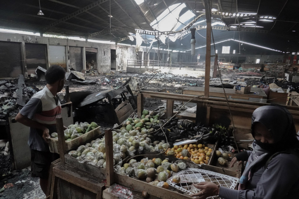 Pedagang memindahkan barang daganganya dari lokasi kebakaran di lantai dua Pasar Wage Purwokerto, Banyumas, Jawa Tengah.