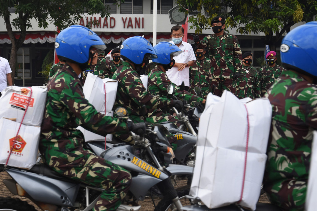 Panglima TNI Marsekal TNI Hadi Tjahjanto (kanan) didampingi Ketua Umum Palang Merah Indonesia (PMI) Jusuf Kalla (kiri) melepas keberangkatan prajurit TNI yang akan menyalurkan paket sembako kepada masyarakat kurang mampu dalam acara bakti sosial memperingati HUT ke-75 TNI di Mabes TNI Cilangkap, Jakarta.