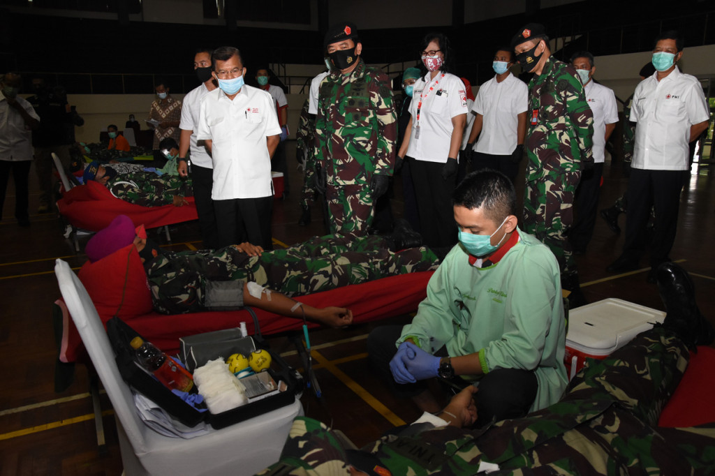 Panglima TNI Marsekal TNI Hadi Tjahjanto (kedua kiri) didampingi Ketua Umum Palang Merah Indonesia (PMI) Jusuf Kalla (kiri) meninjau kegiatan donor darah dalam acara bakti sosial memperingati HUT ke-75 TNI di Mabes TNI Cilangkap, Jakarta.