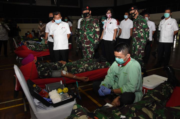 Panglima TNI Marsekal TNI Hadi Tjahjanto (kedua kiri) didampingi Ketua Umum Palang Merah Indonesia (PMI) Jusuf Kalla (kiri) meninjau kegiatan donor darah dalam acara bakti sosial memperingati HUT ke-75 TNI di Mabes TNI Cilangkap, Jakarta.