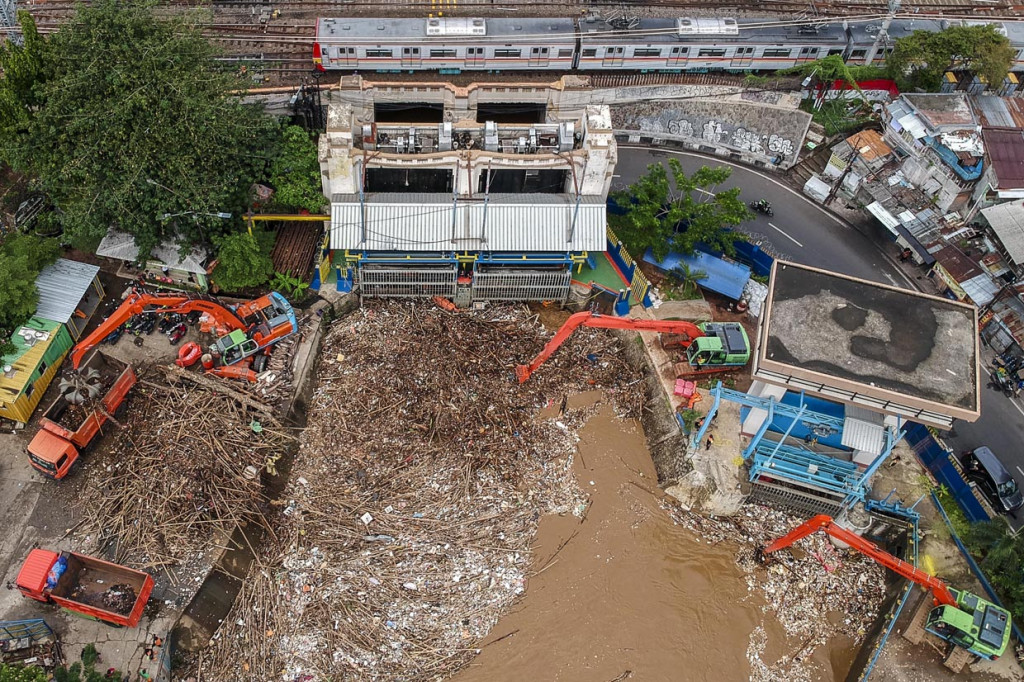 Foto aerial Petugas Dinas Kebersihan DKI Jakarta menggunakan alat berat membersihkan sampah di pintu air Manggarai, Jakarta. ANTARA Foto/Galih Pradipta