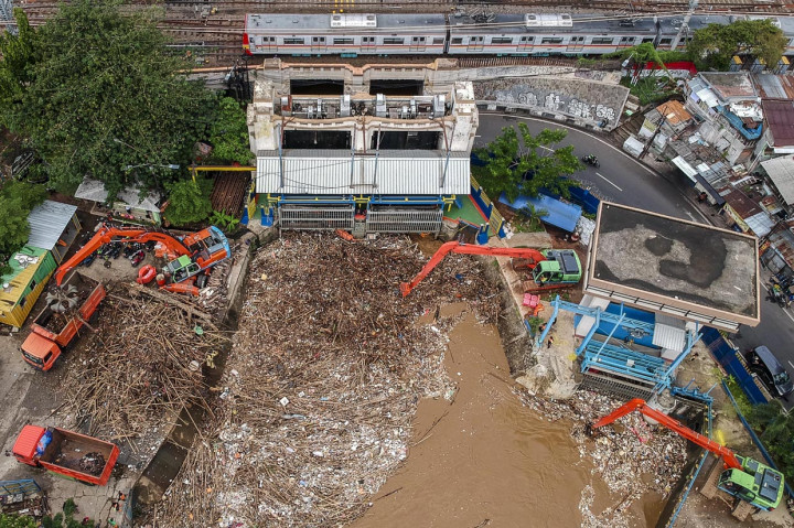 Foto aerial Petugas Dinas Kebersihan DKI Jakarta menggunakan alat berat membersihkan sampah di pintu air Manggarai, Jakarta. ANTARA Foto/Galih Pradipta