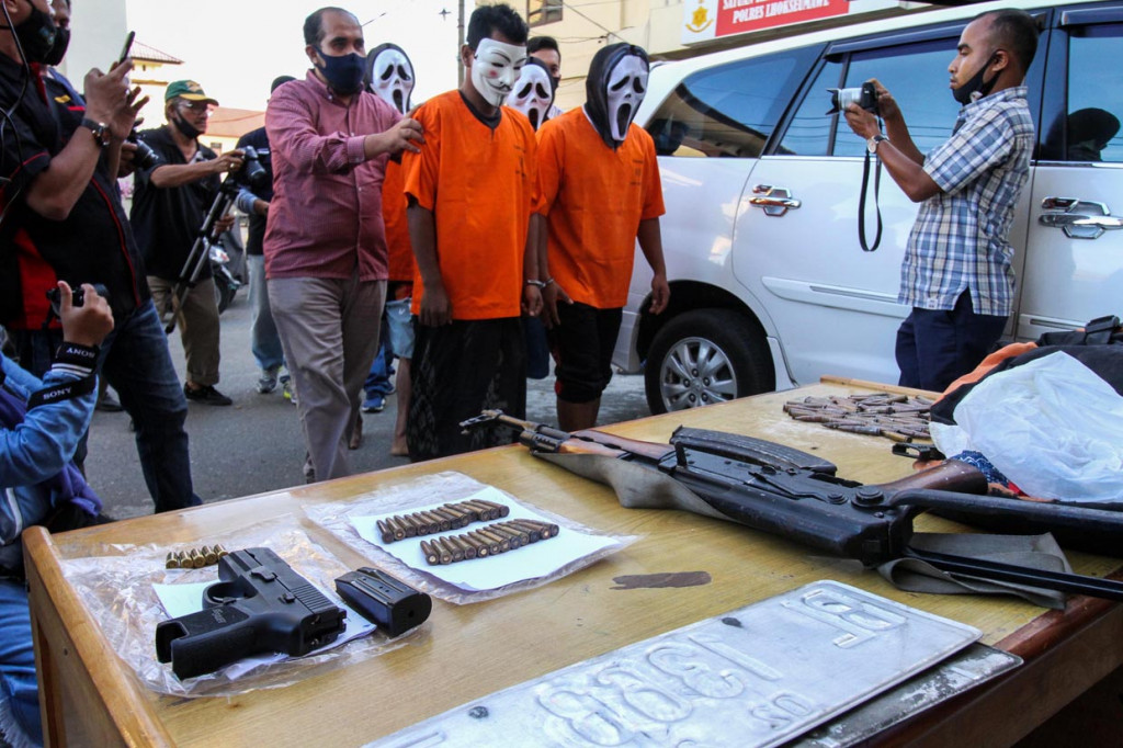 Polisi Satuan Reserse Kriminal menghadirkan Empat tersangka penculikan bersama barang bukti senjata api, di Polres Lhokseumawe, Aceh.
