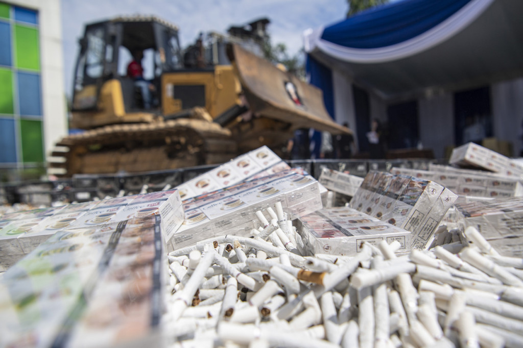 Petugas mengoperasikan alat berat untuk memusnakan barang yang menjadi milik negara di Palembang, Sumatera Selatan.