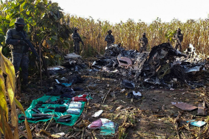 Petugas berjaga-jaga di dekat puing-puing setelah sebuah pesawat yang membawa obat-obatan terlarang jatuh di Desa Santa Marta Salinas, Kotamadya Chisec, Guatemala, pada Rabu, 23 September 2020 waktu setempat.