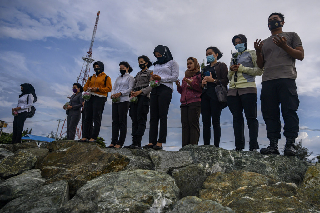 Sejumlah anggota kepolisian berdoa sebelum menabur bunga di bekas lokasi tsunami di Pantai Talise, Palu, Sulawesi tengah. ANTARA Foto/Basri Marzuki