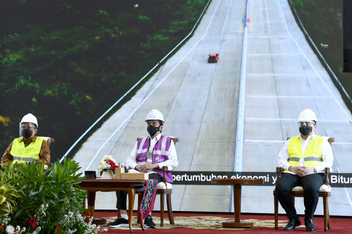 Meski melakukan peresmian dari Istana, Jokowi tetap mengenakan helm dan rompi proyek layaknya para pejabat yang berada di lokasi jalan tol.