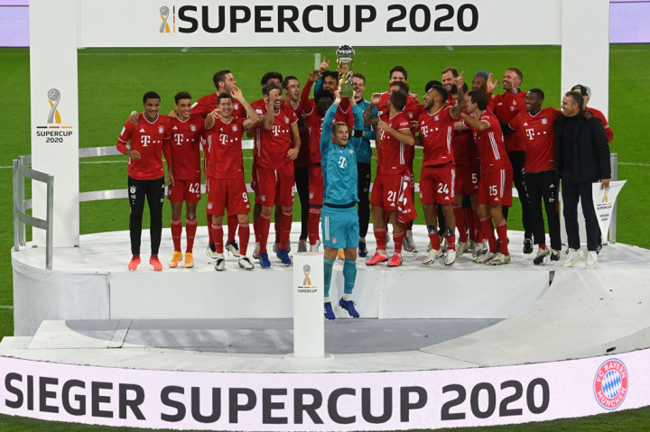 Kapten tim Bayern Muenchen Manuel Neuer mengangkat trofi PIala Super Jerman diikuti sorak-sorai rekan rekan setimnya di Allianz Arena, Kamis, 1 Oktober 2020 dini hari WIB.