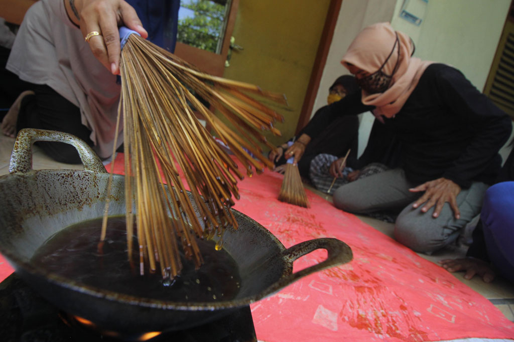 Perajin membuat batik sapu lidi di kawasan Jetis Kulon, Wonokromo, Surabaya, Jawa Timur.