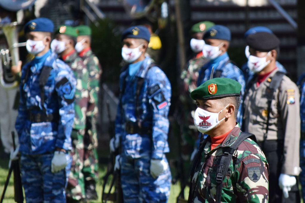 Peserta dengan memakai masker mengikuti upacara peringatan Hari Kesaktian Pancasila di areal Monumen Korban Keganasan Partai Komunis Indonesia (PKI) di Kresek, Kabupaten Madiun, Jawa Timur.