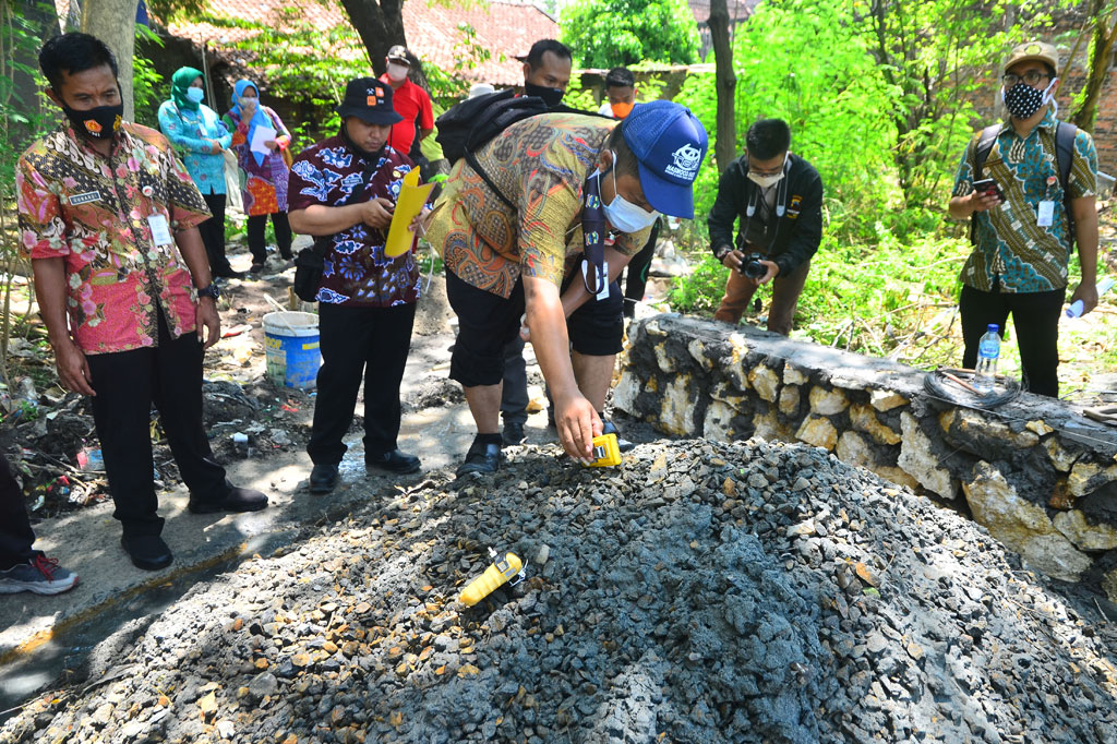 Kepala Seksi Energi Dinas ESDM wilayah Kendeng Selatan Sinung Sugeng Arianto (tengah) mengecek kadar gas di lokasi semburan air dan gas di Desa Manggarmas, Godong, Grobogan.