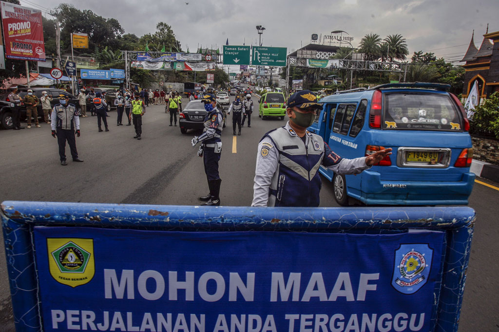 Petugas gabungan melakukan pembatasan kendaraan di Jalan Raya Puncak, Gadog, Kabupaten Bogor, Jawa Barat, Sabtu, 3 Oktober 2020.