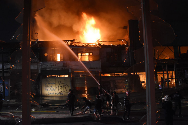 Petugas Pemadam Kebakaran dibantu warga memadamkan api yang menghanguskan bangunan toko dan bekas gedung bioskop Grand Theater di kawasan Senen, Jakarta, Kamis, 8 Oktober 2020 malam.