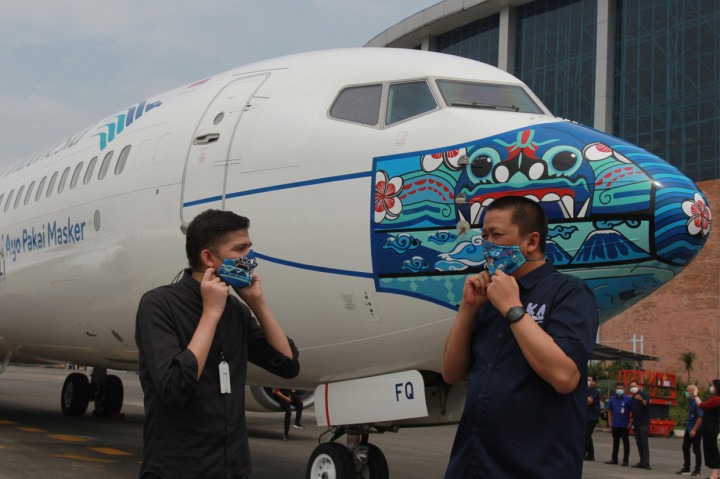 Direktur Utama Garuda Indonesia Irfan Setiaputra (kanan) berbincang dengan pemenang lomba desain livery masker pesawat Jailani (kiri) saat peluncuran pesawat Garuda Indonesia Boing 737-800 NG bercorak khusus yang menampilkan visual masker bertema 