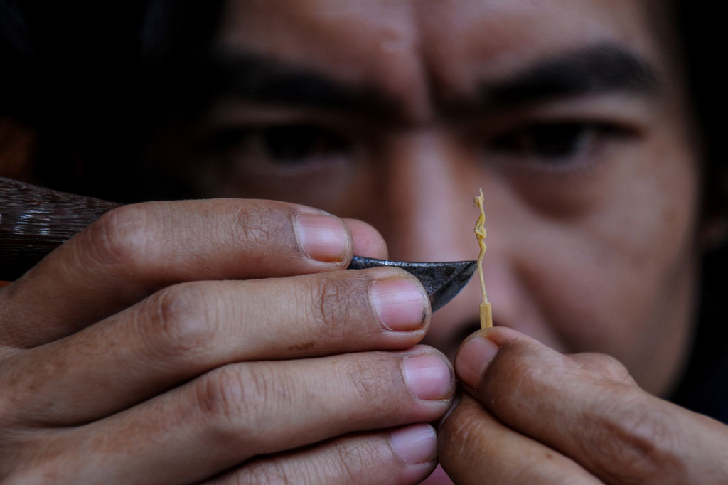 Perajin menyelesaikan produksi patung mini jenis tanimbar dengan bahan baku korek api di Jatinangor, Kabupaten Sumedang, Jawa Barat.