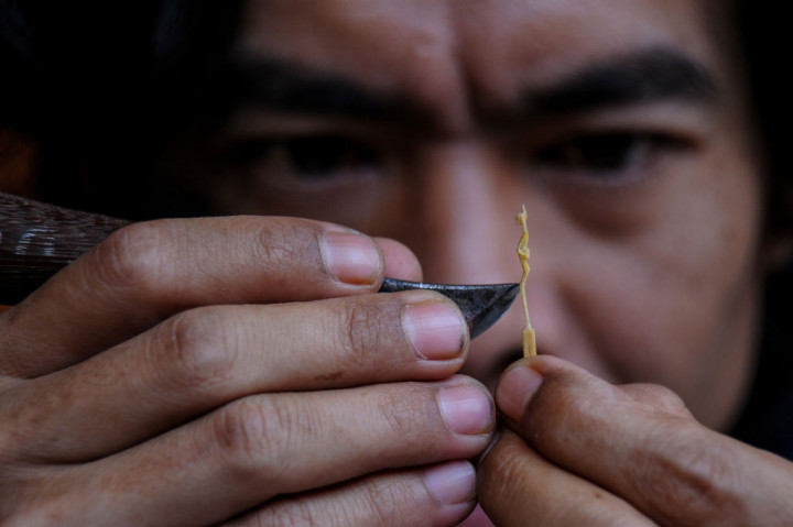 Perajin menyelesaikan produksi patung mini jenis tanimbar dengan bahan baku korek api di Jatinangor, Kabupaten Sumedang, Jawa Barat.