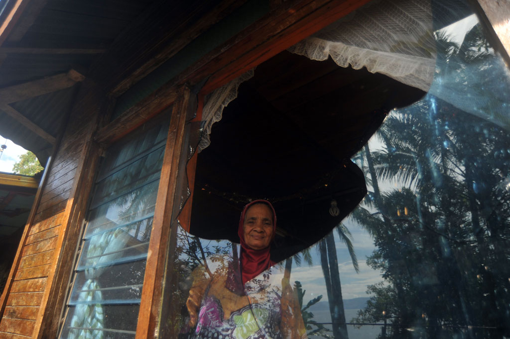 Warga melihat di kaca rumahnya yang hancur akibat dilempar batu di Jorong Suduik, Nagari Sumpu, Kabupaten Tanah Datar, Sumatera Barat, Selasa, 13 Oktober 2020.