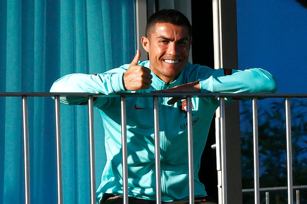 Pemain depan Portugal Cristiano Ronaldo mengacungkan jempol saat ia menyaksikan sesi latihan rekan satu timnya dari balkon di Kamp pelatihan timnas di Oeiras, di pinggiran Lisbon pada Selasa, 13 Oktober 2020.