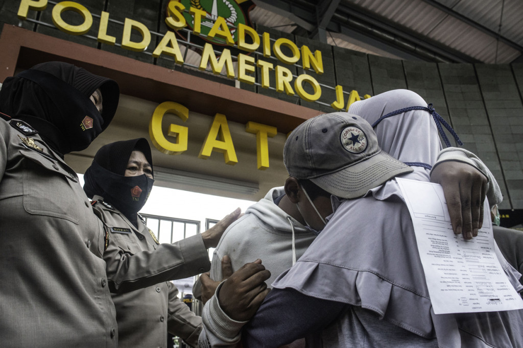 Peserta aksi memeluk orang tuanya usai dipulangkan di Polda Metro Jaya, Jakarta.