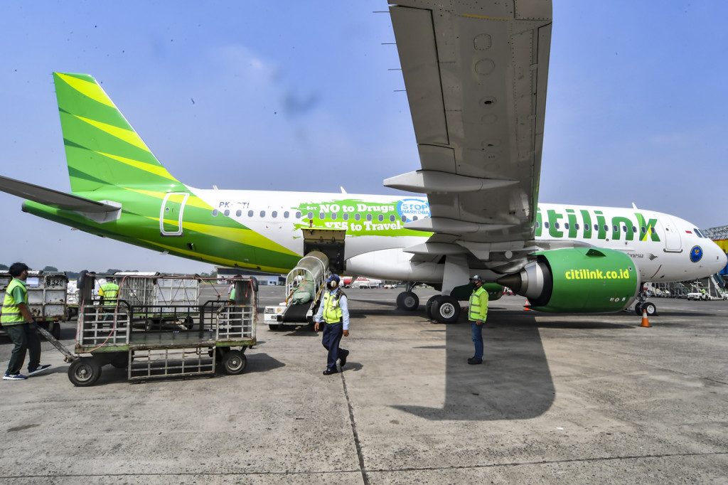 Petugas bagasi pesawat memasukkan barang milik penumpang ke dalam pesawat usai acara penandatanganan perjanjian kerjasama antara Citilink Indonesia dengan BNN di Bandara Halim Perdanakusuma, Jakarta.