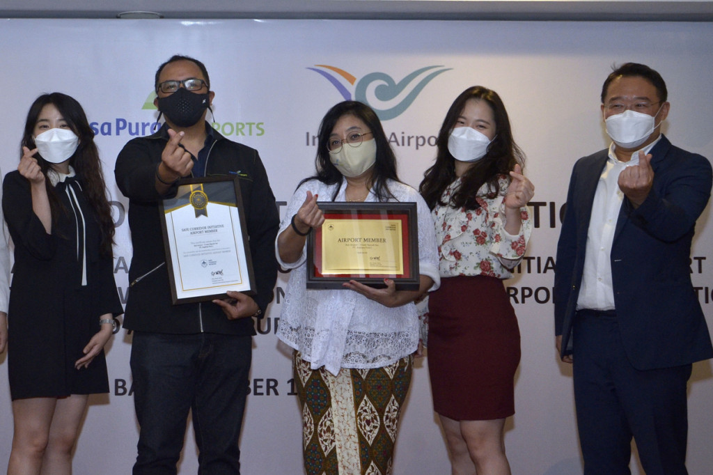 Deputy Director of Overseas Business Group Incheon International Airport Corporation (IIAC) Korea Selatan Vin Kim (kanan), Direktur Pemasaran dan Pelayanan PT Angkasa Pura I (Persero) Devy Suradji (tengah) dan Direktur Pengembangan Usaha PT Angkasa Pura I (Persero) Dendi T. Danianto (kedua kiri) berfoto bersama saat penyerahan sertifikat Safe Corridor Initiative (SCI) kepada Bandara I Gusti Ngurah Rai di Badung, Bali.