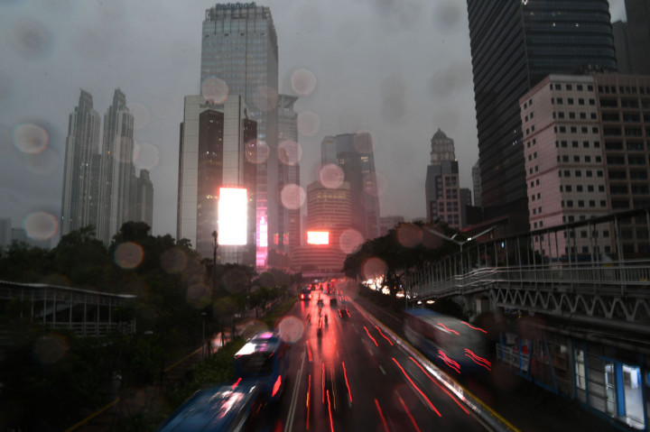 Kendaraan bermotor melintas di Jalan Jenderal Sudirman saat hujan turun di Jakarta.
