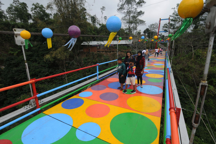Warga setempat memanfaatkan fasilitas umum berupa jembatan gantung dengan mengecat motif polkadot warna-warni sebagai daya tarik lokasi wisata baru di lereng Gunung Merapi sehingga dapat meningkatkan perekonomian warga.