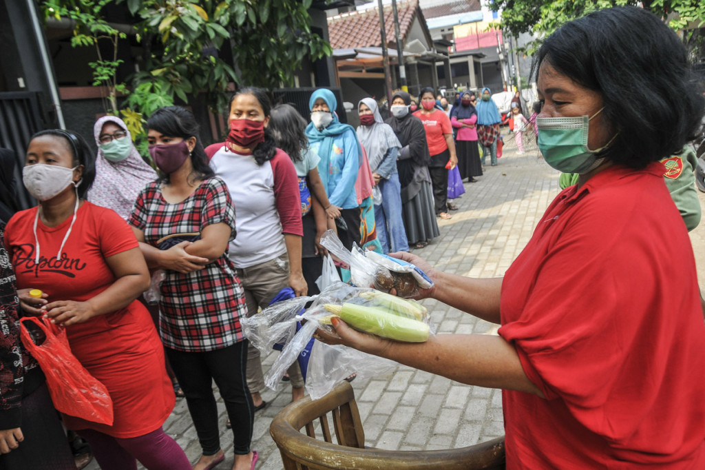 Sejumlah warga antre saat berbelanja di pasar 