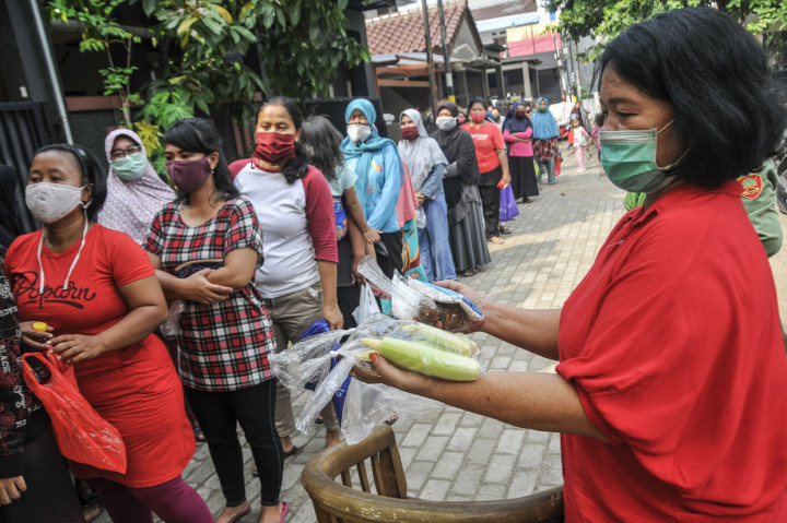 Sejumlah warga antre saat berbelanja di pasar 