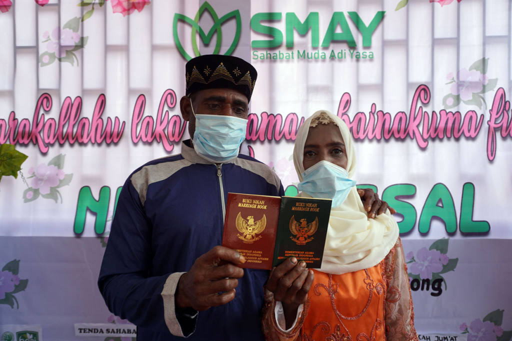 Sepasang pengantin menunjukan buku nikah usai mengikuti proses Ijab Kabul di Kota Sorong, Papua Barat.