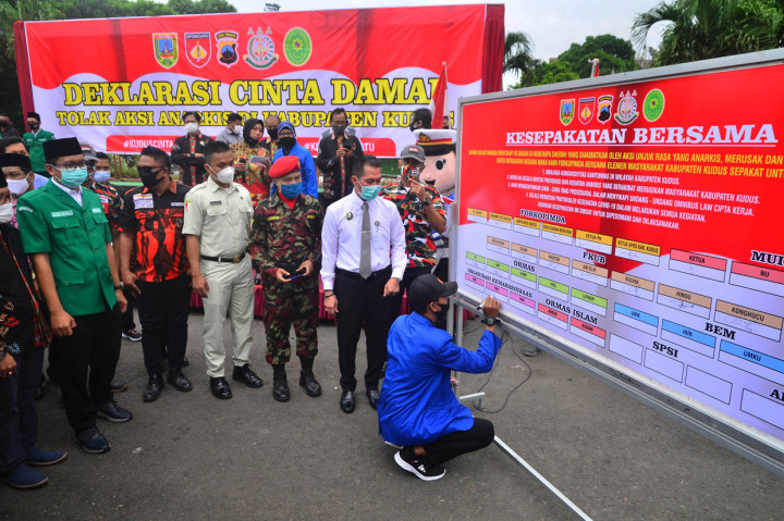 Seorang perwakilan dari mahasiswa menandatangani papan yang berisi menolak anarkisme saat Deklarasi Cinta Damai di Kudus, Jawa Tengah.
