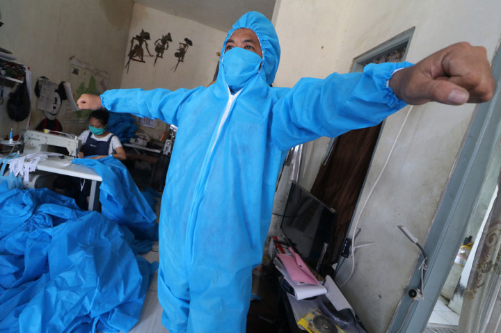 Dalam sebulan, jumlah kasus covid-19 Indonesia naik tinggi sehingga kebutuhan alat pelindung diri (APD) melonjak. Pemerintah berburu cepat. Sekurangnya 11 juta
APD berhasil dihimpun dari belasan negara dan lembaga-lembaga non-pemerintah. Produksi APD dalam negeri digenjot. Sejumlah sekolah kejuruan, dan industri rumahan digandeng memenuhi kebutuhan. Hasilnya produksi APD saat ini mencapai 17 juta per bulan. ANTARA FOTO/Prasetia Fauzani