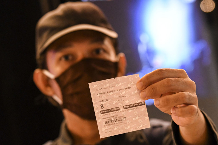 Pengunjung menunjukkan tiket film yang akan ditonton di salah satu bioskop di Jakarta.